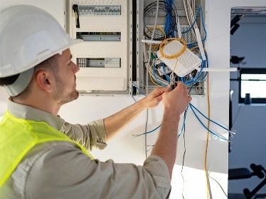 A person fixing an electricity box.